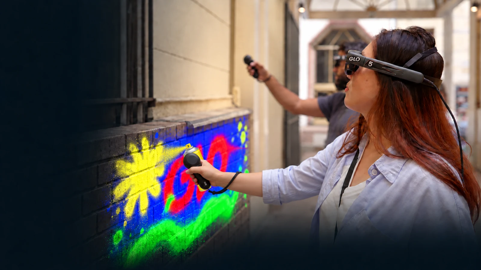 A guest using her controller and a yellow virtual spray can to paint a yellow star on a digital graffiti wall